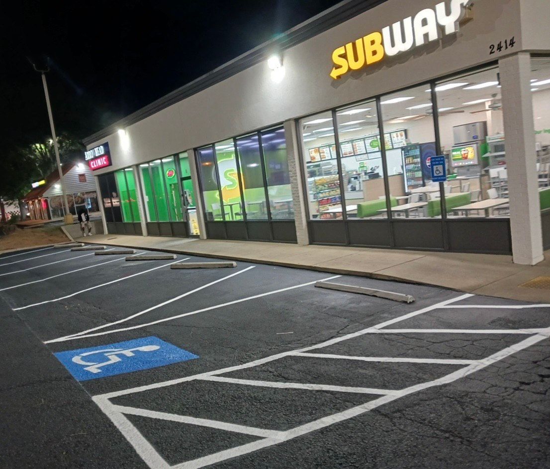 Empty asphalt parking lot with white painted lines for parking spaces.