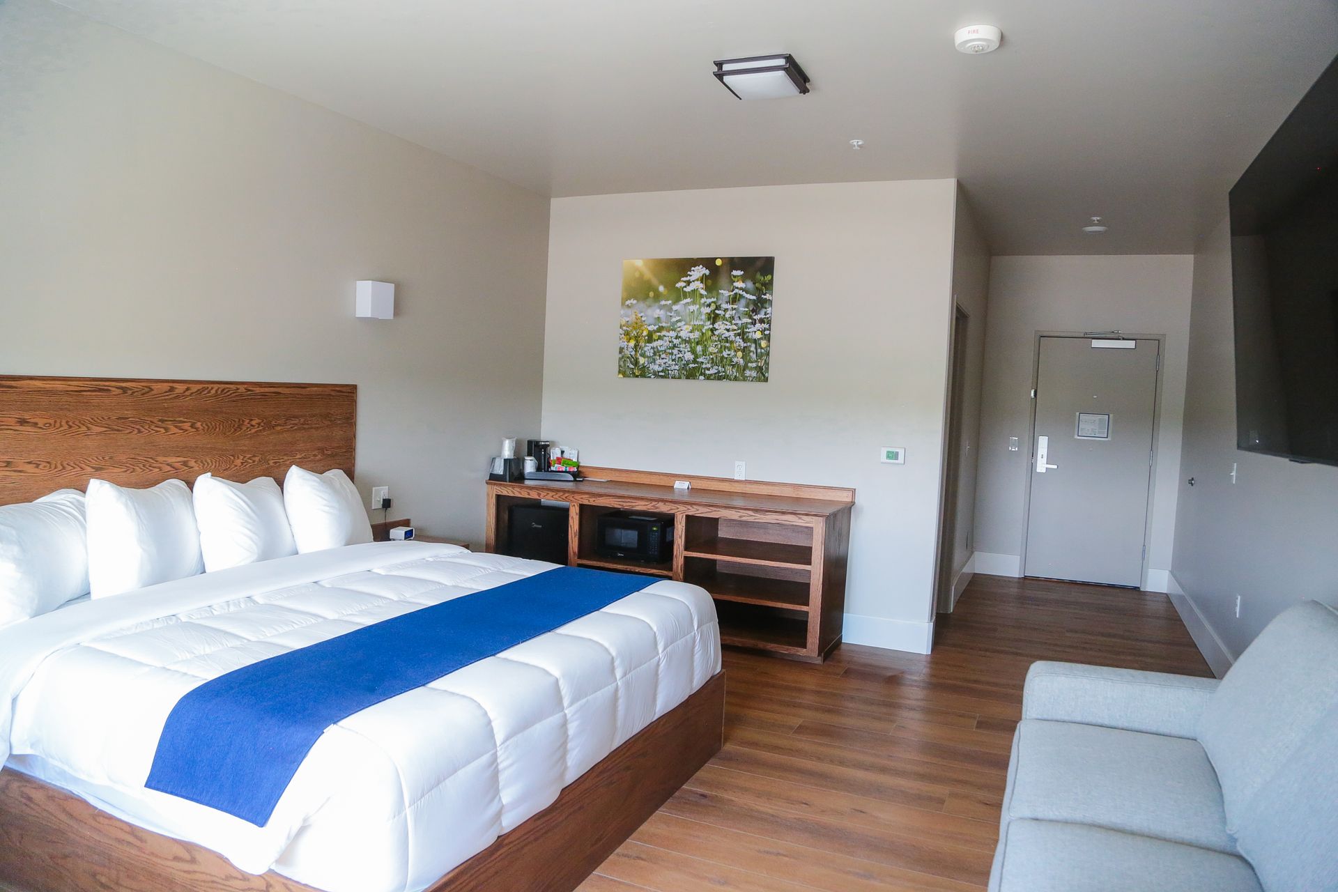 Hotel room with two beds, wooden desk, and a small seating area