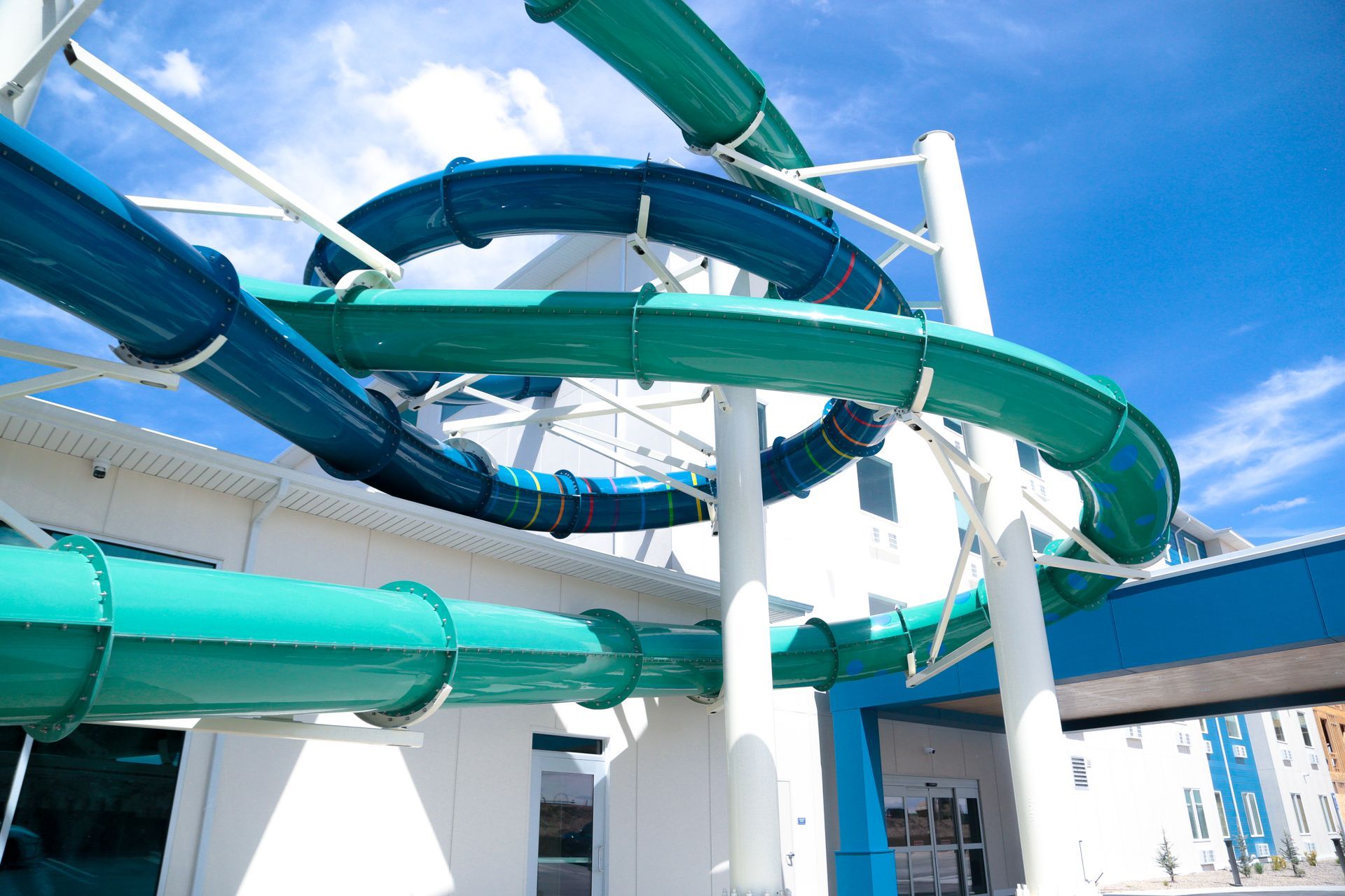 Colorful twisting water slide tubes against a blue sky at an amusement park