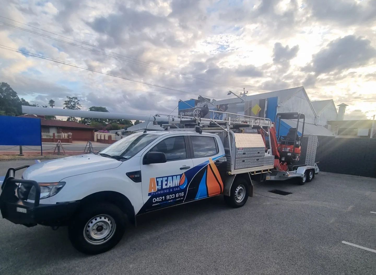 A white truck with a trailer attached to it is parked in a parking lot.