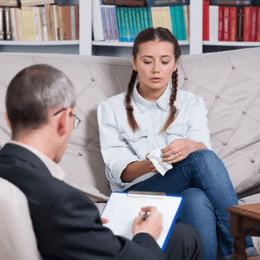 Woman speaking with a counselor during a therapy session in a bright office