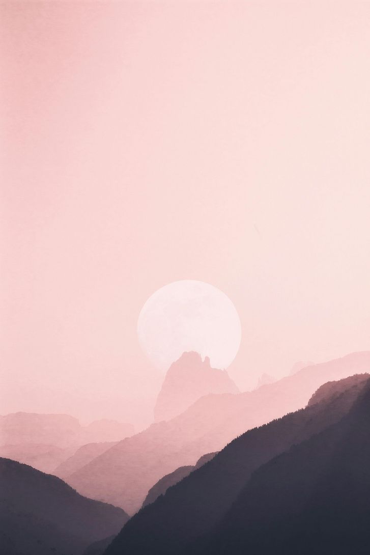 Pink sunrise over misty mountain silhouettes