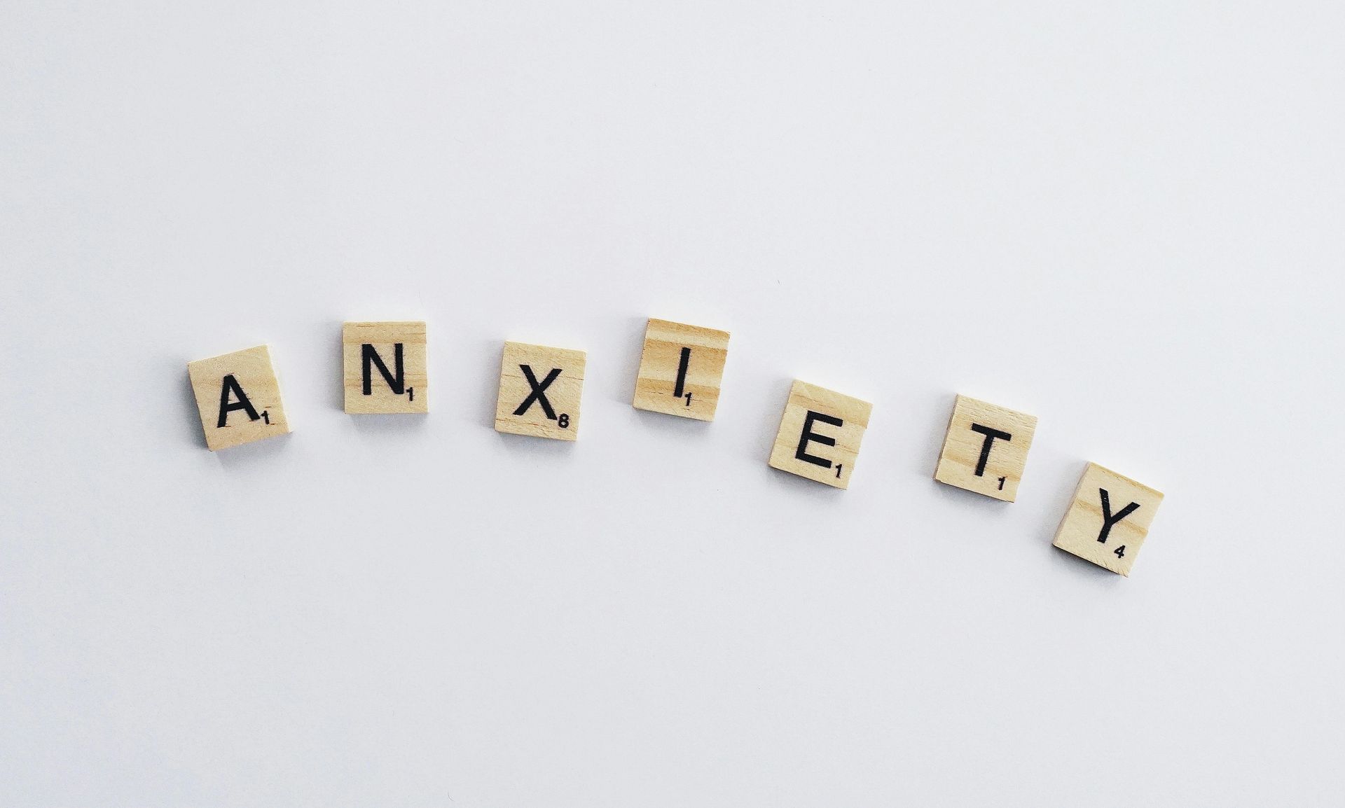 Scrabble tiles spelling “ANXIETY” on a white background