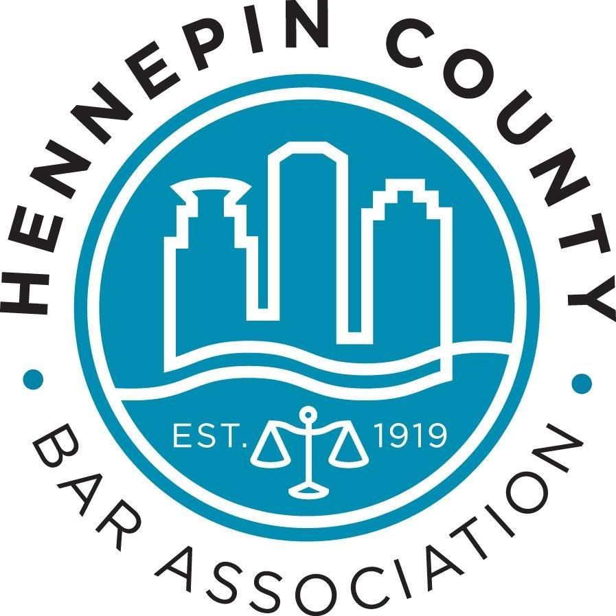 Circular logo for Hennepin County Bar Association, featuring Minneapolis skyline silhouettes, a scale of justice, and 1919.
