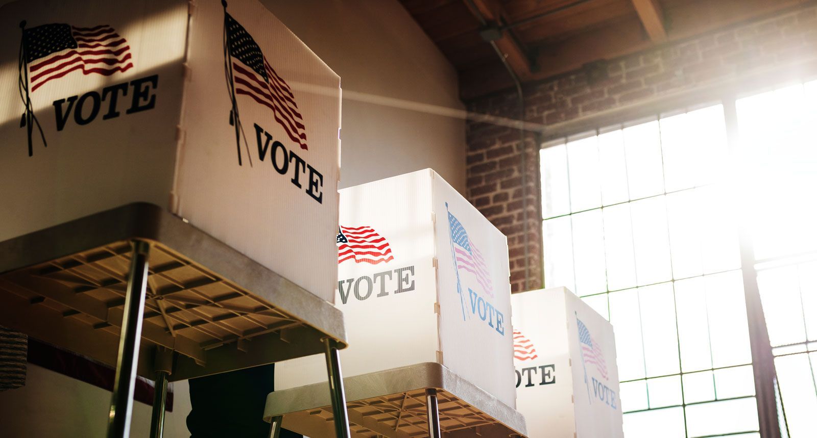A row of voting booths featuring American flags and the word