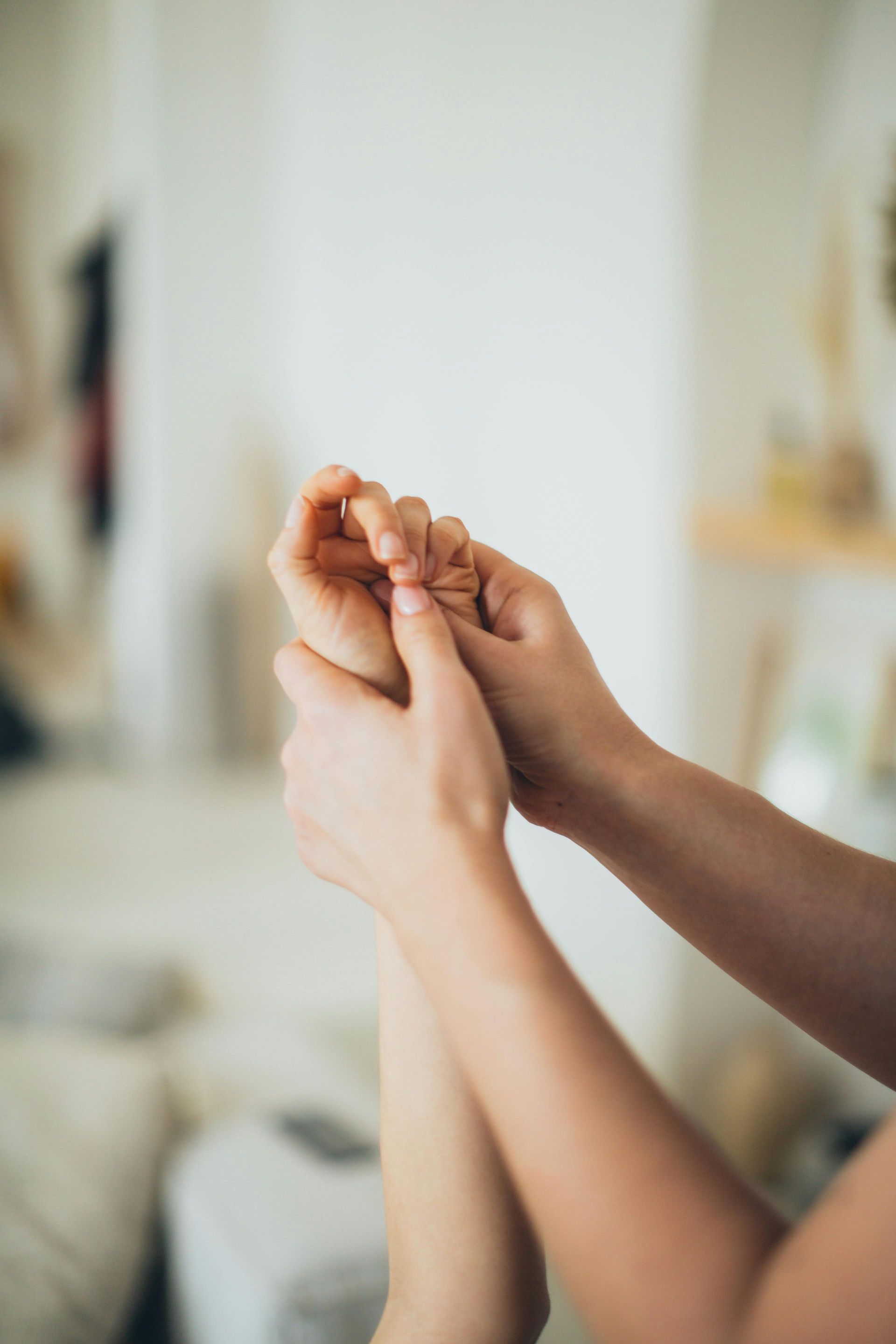 A person is taking a person 's pulse on a wooden table.