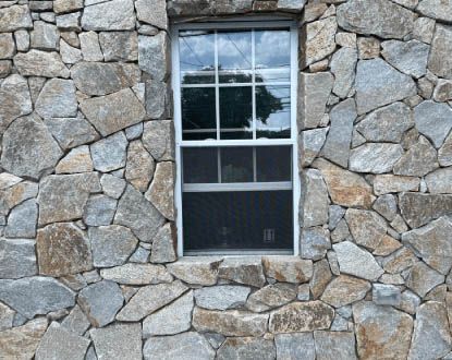 A stone wall with a window in it