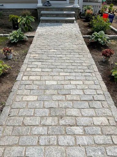 A brick walkway leading to the front door of a house.