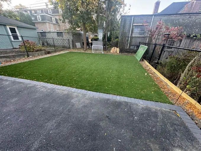 A backyard with a lot of grass and a house in the background.
