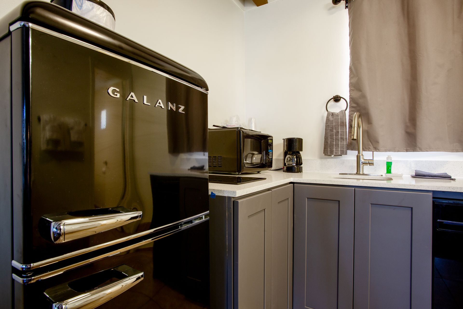 Kitchenette at Dreamcatcher Inn Sedona with black refrigerator and sink