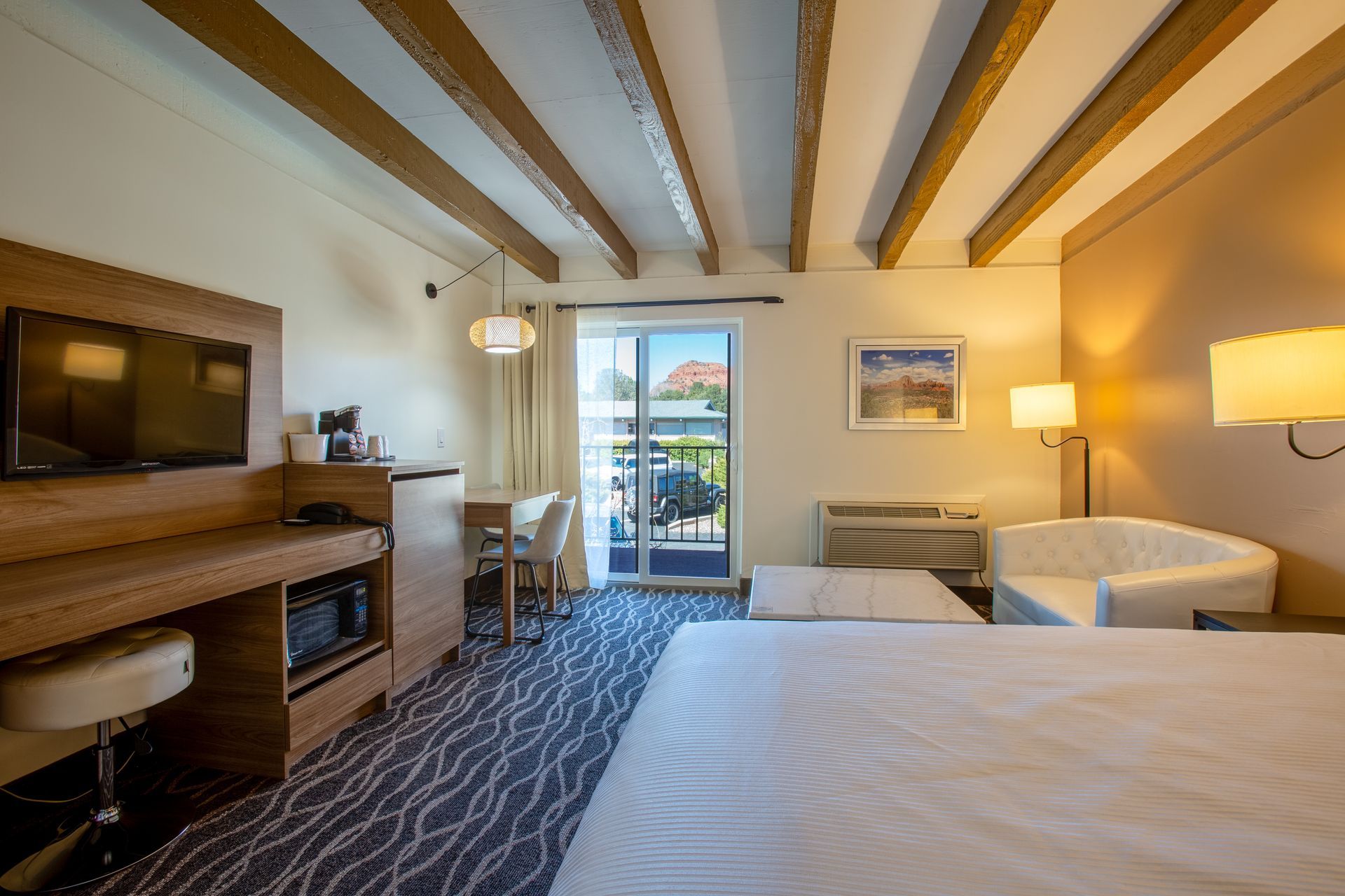 Dreamcatcher Inn Sedona hotel room with king-size bed, chair, work desk, and flat-screen TV