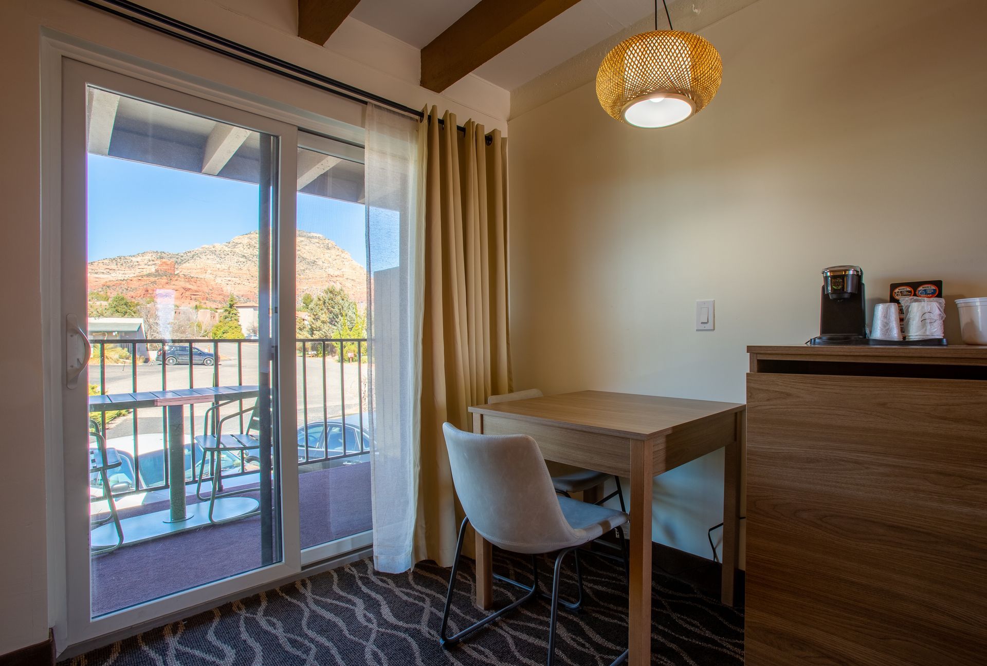 Dreamcatcher Inn Sedona hotel room with table, chairs, and sliding glass door opening to private balcony