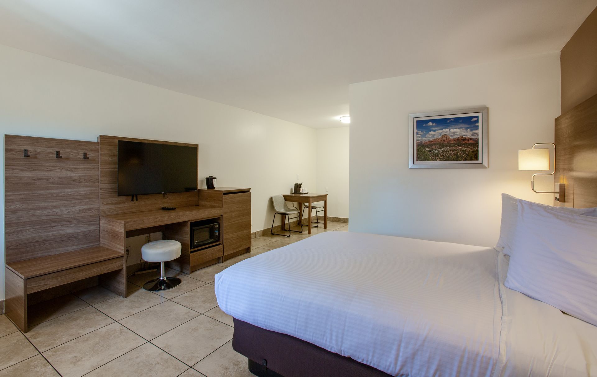 Dreamcatcher Inn Sedona hotel room with king-size bed, flat-screen TV, desk, and chairs