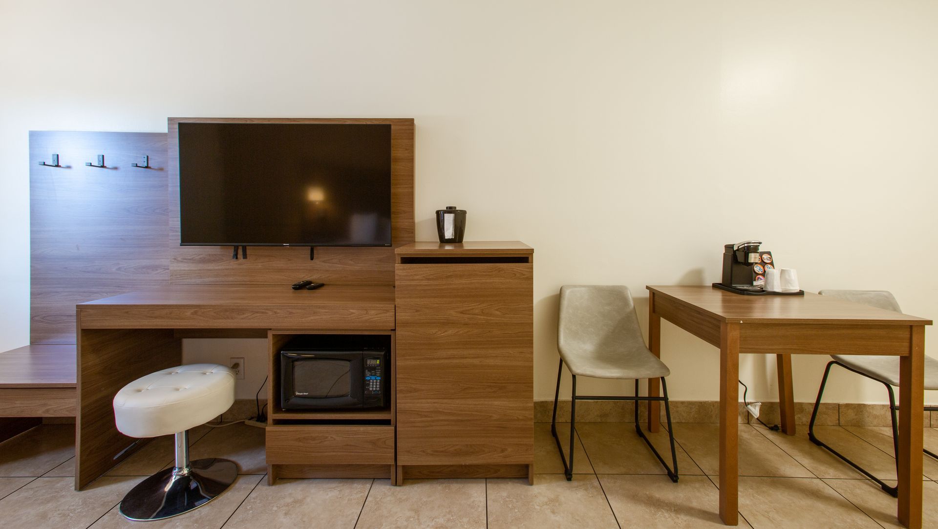 Dreamcatcher Inn Sedona hotel room with desk, chairs, microwave, and flat-screen TV