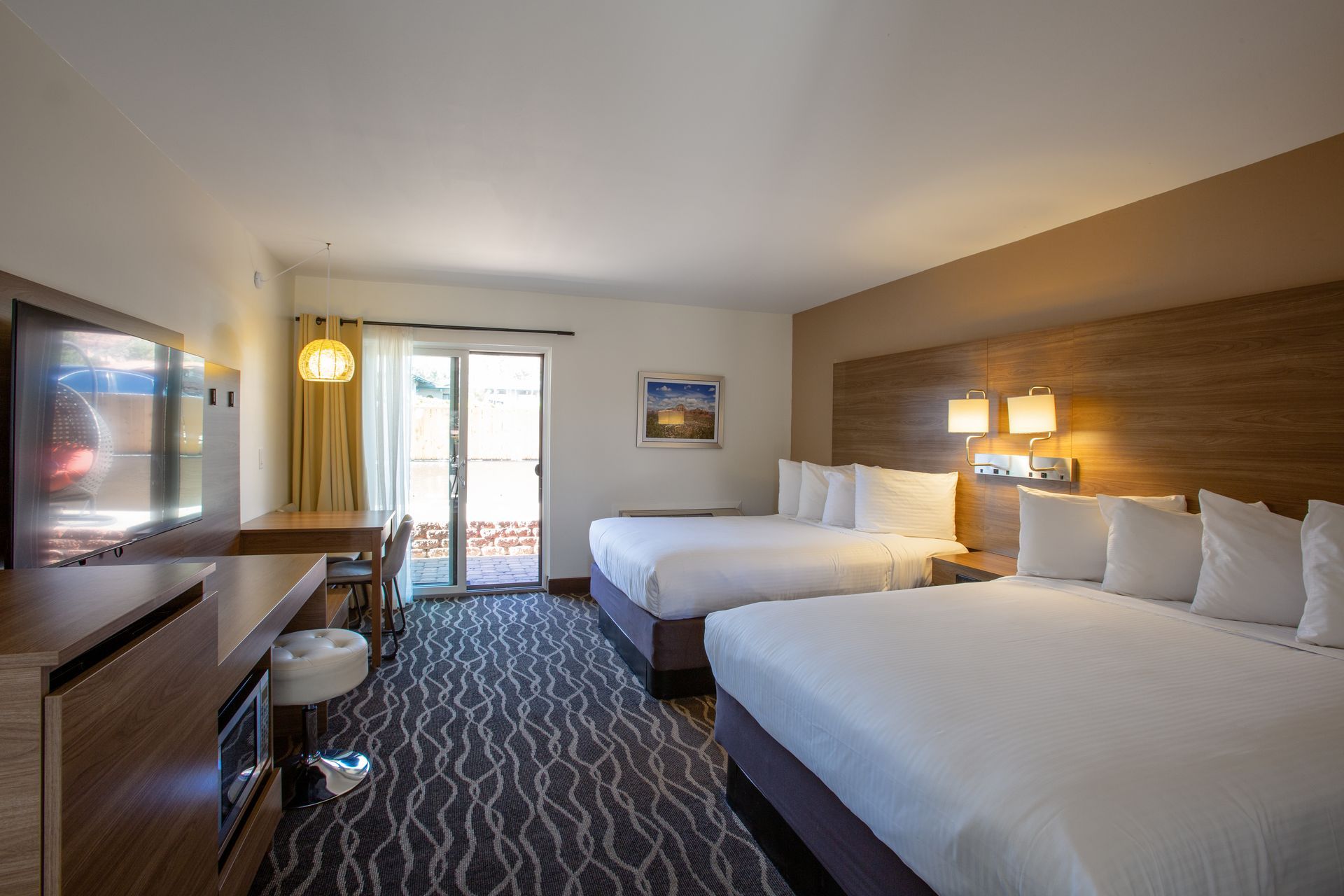 Dreamcatcher Inn Sedona hotel room with two beds, work desk, and flat-screen TV for a comfortable stay