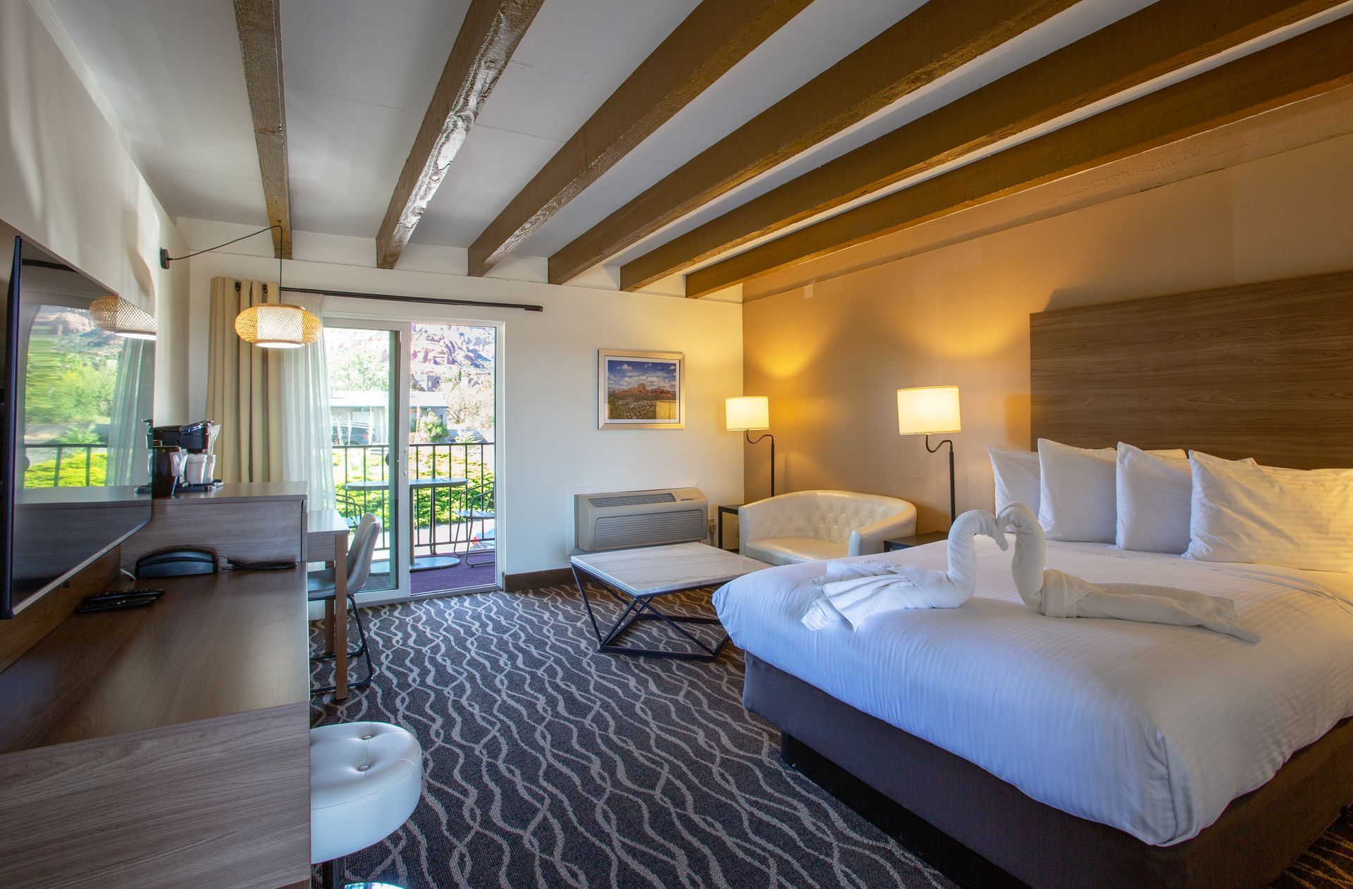 Dreamcatcher Inn Sedona hotel room with king-size bed, work desk, chair, and flat-screen TV