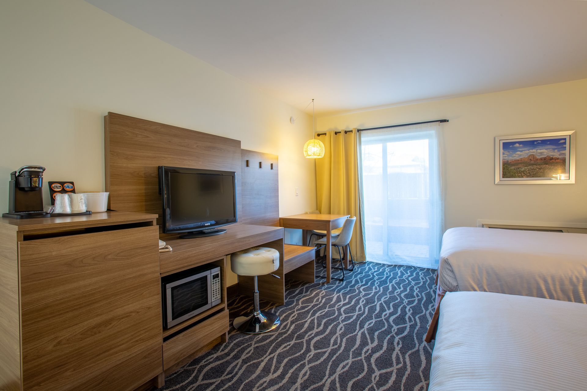 Dreamcatcher Inn Sedona hotel room with two beds, work desk, flat-screen TV, and microwave for guest convenience