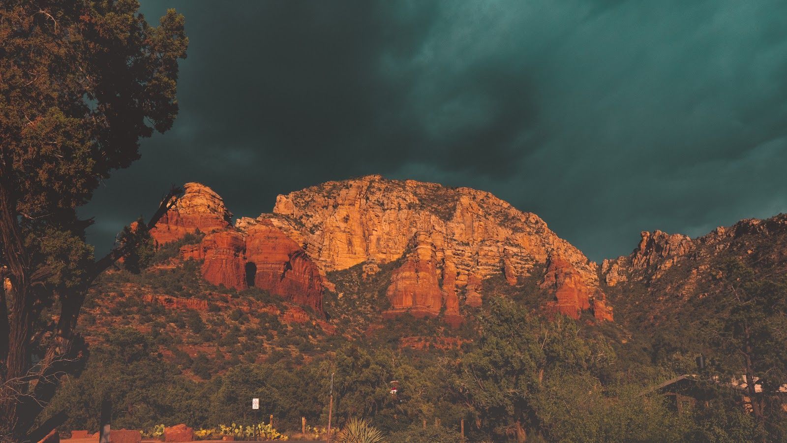 Storm clouds gathering over Sedona red rock formations, setting the mood for local ghost stories