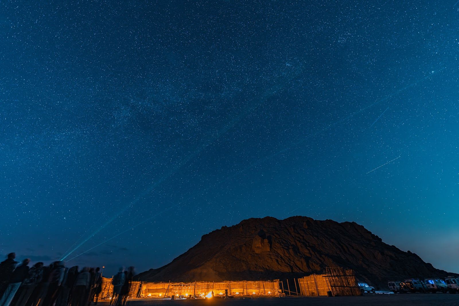 Group of stargazers on a night sky tour as a guide points out stars with a green laser