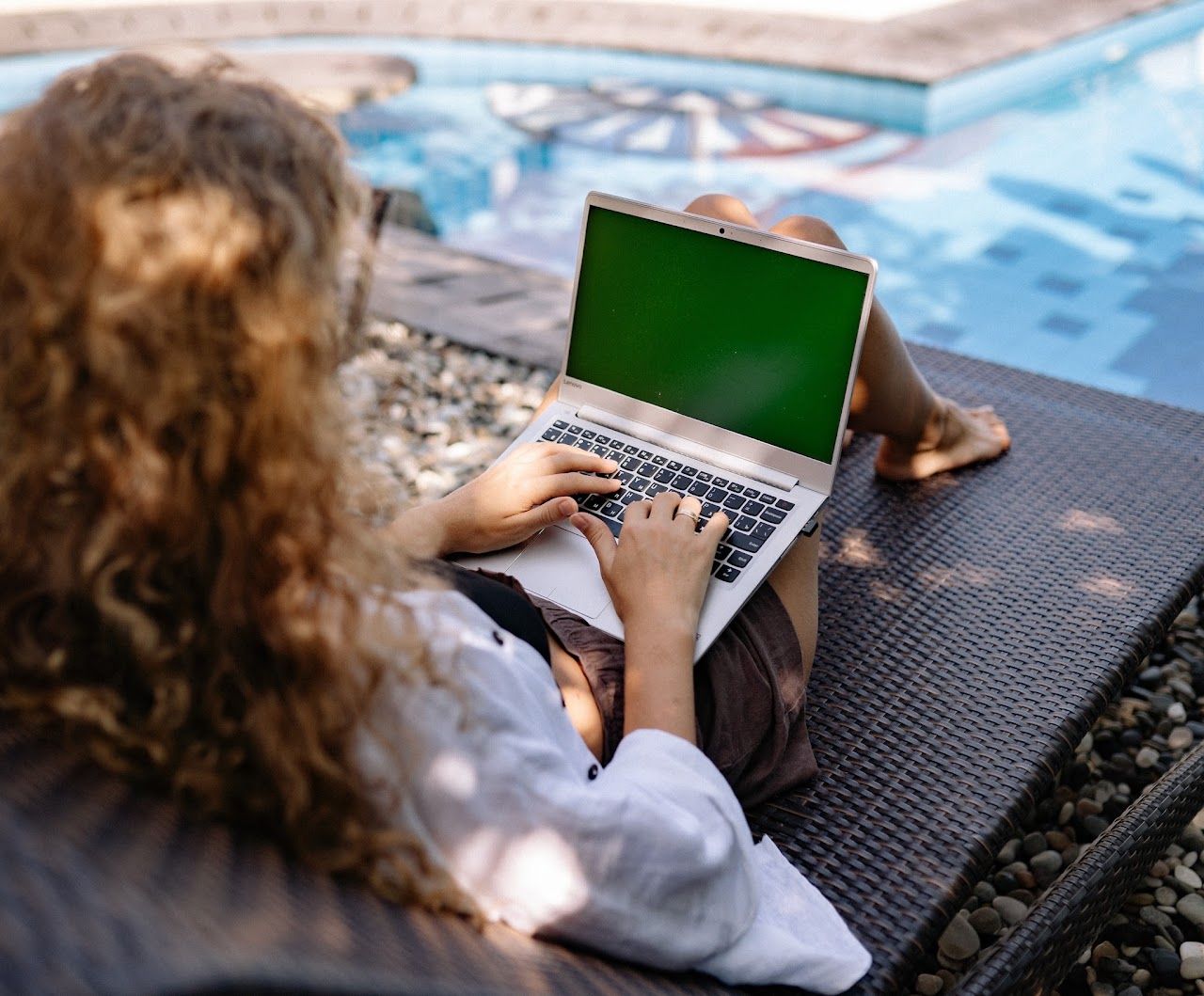 Remote worker relaxing poolside with laptop at Dreamcatcher Inn