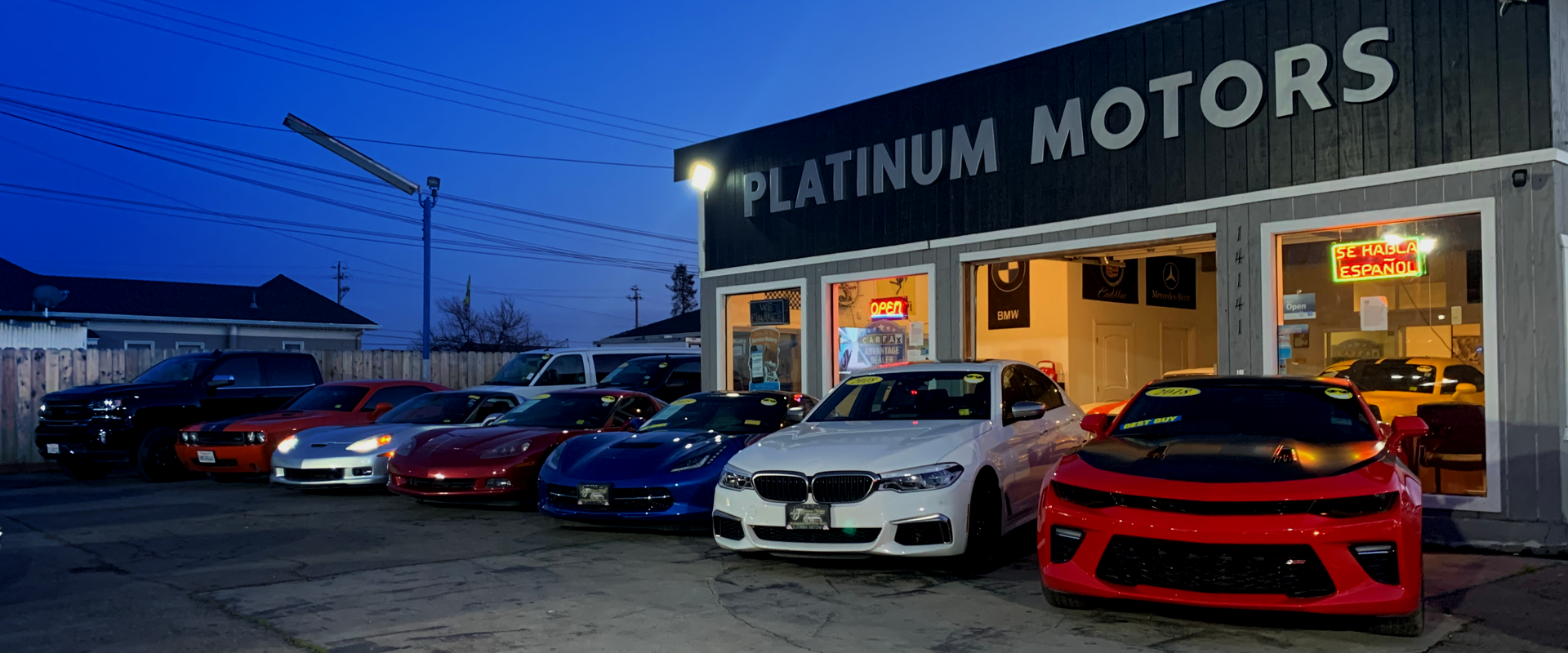 A row of cars are parked in front of a platinum motors car dealership. | Platinum Motors Martinez
