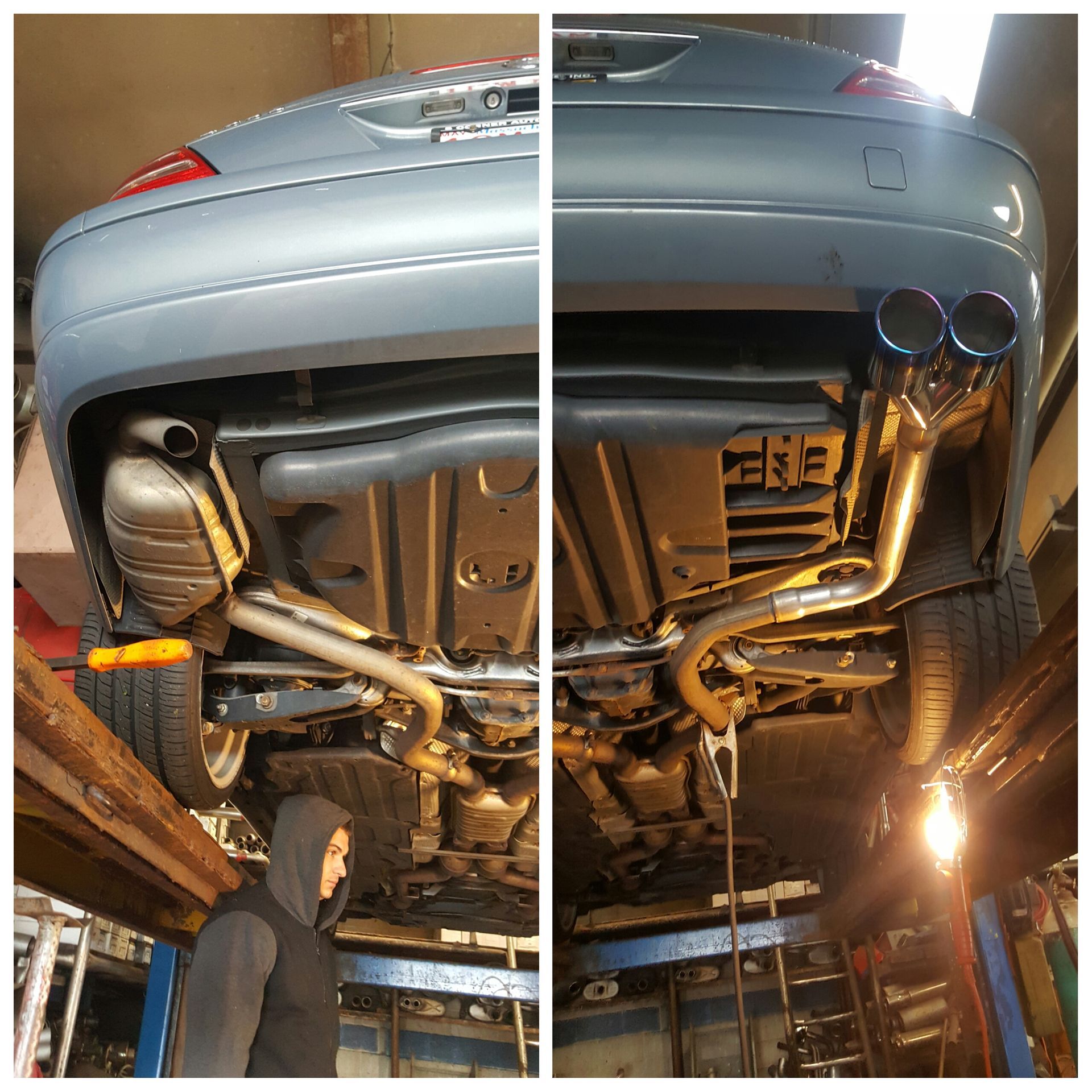 Silver car on a lift, showing the underside and dual exhaust system in a garage.