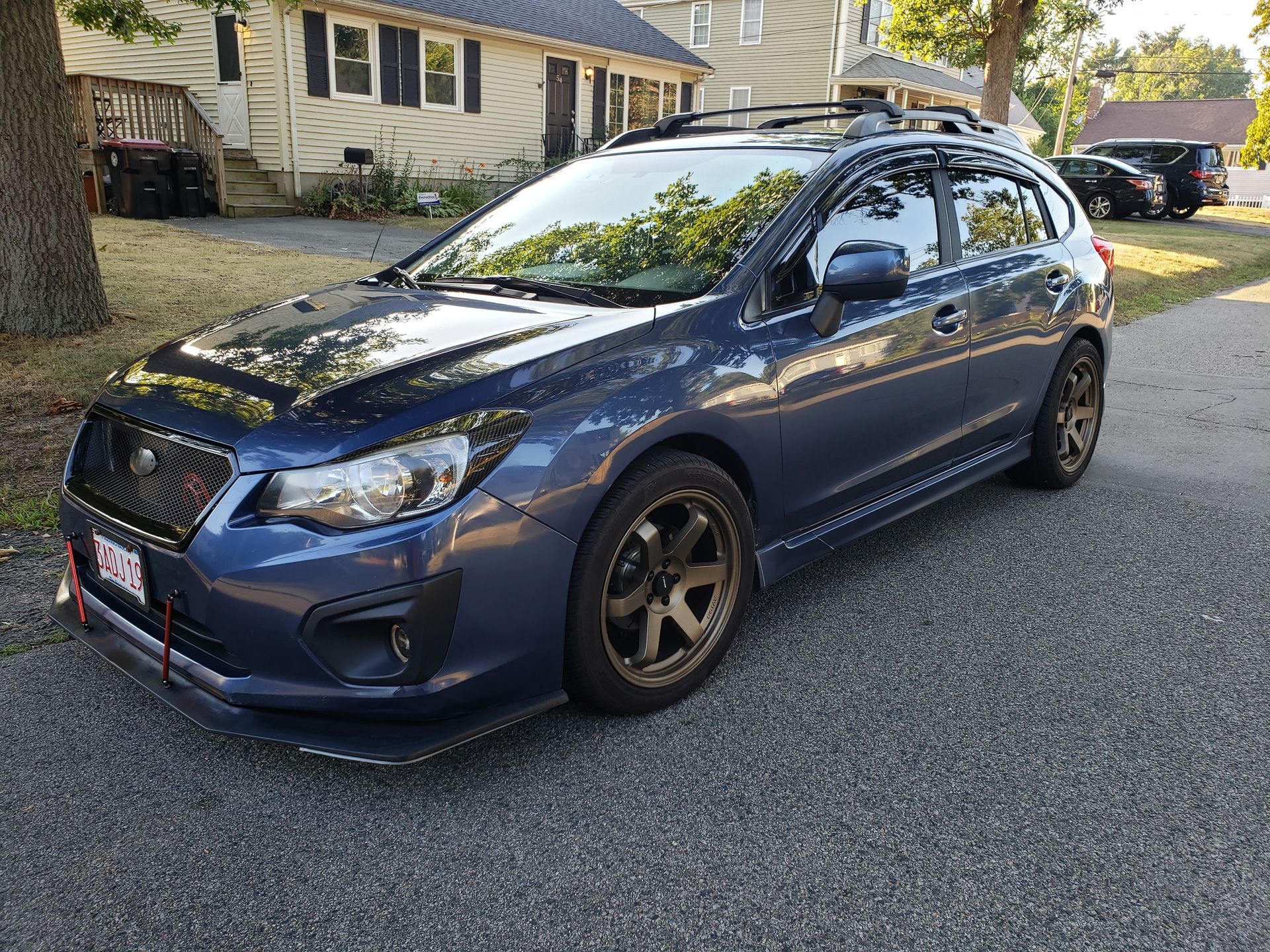 Blue hatchback car parked on a residential street in daylight