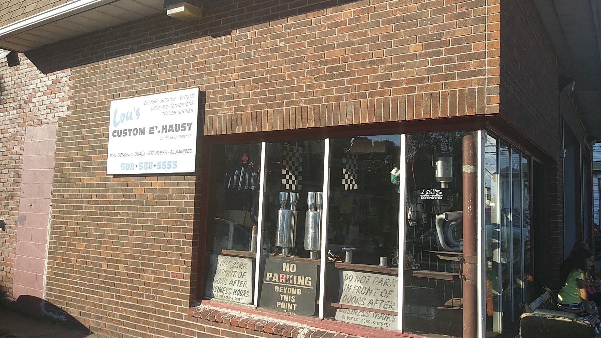 Brick storefront with a window sign for a dental practice and a covered entrance.