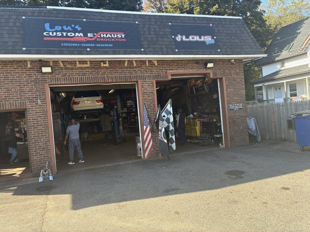 Open garage of a custom car audio shop with signs, equipment inside, and a person standing near the entrance