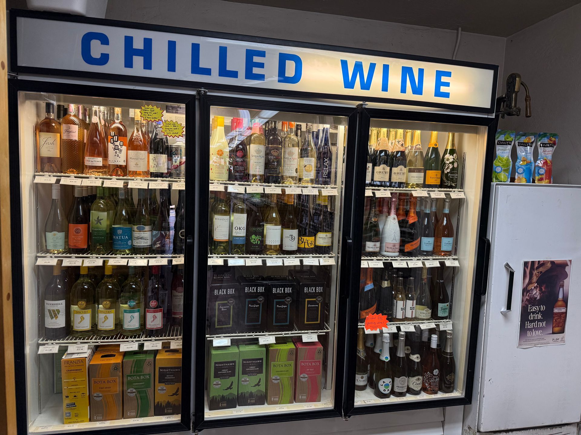 A bunch of wine bottles are sitting on a rack in a store.