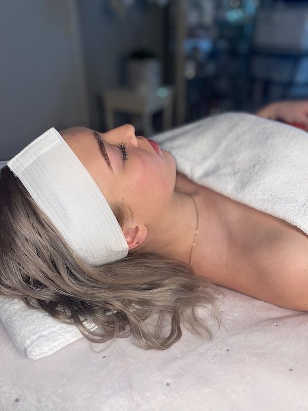 A woman is laying on a bed with a headband on her head.