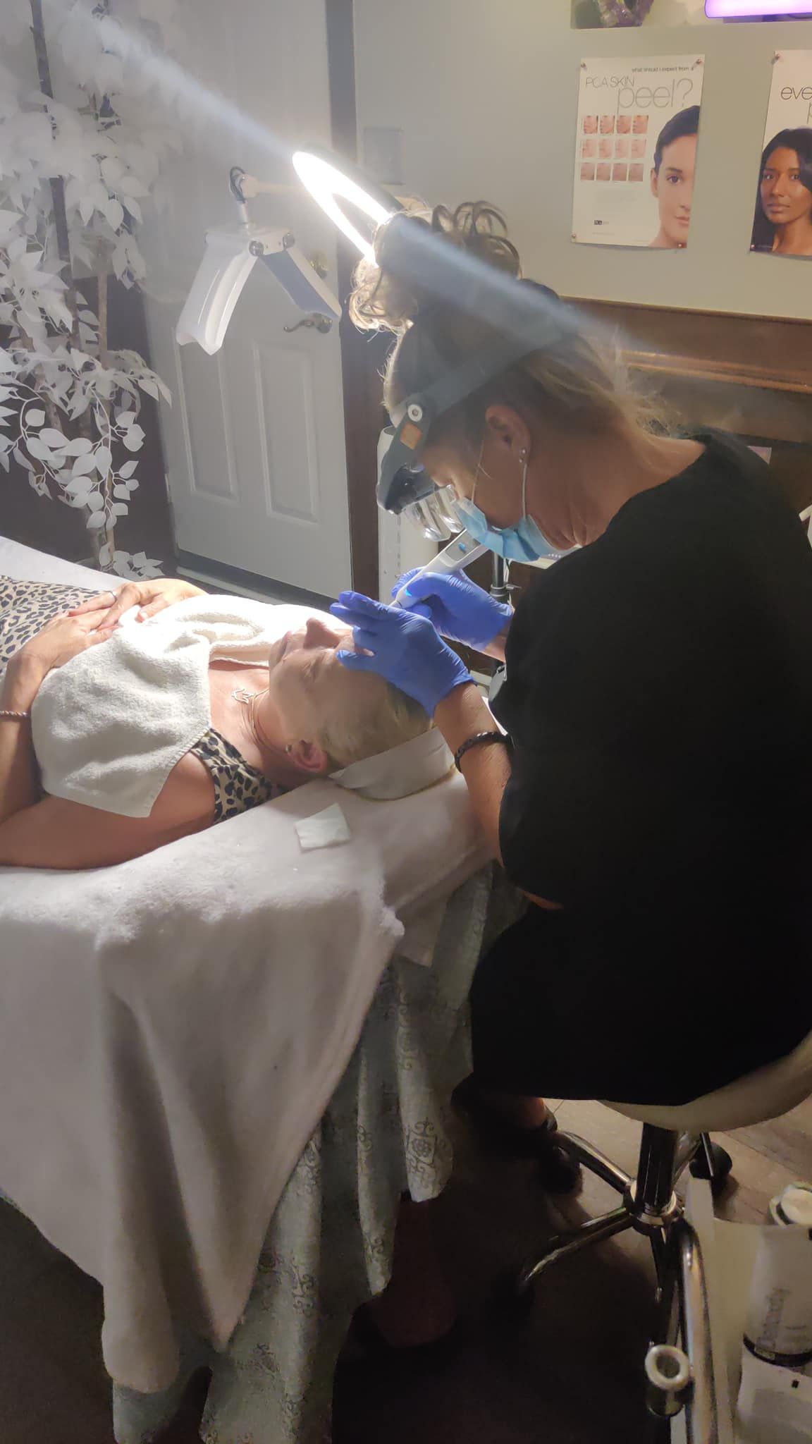 a woman is laying on a bed getting a facial treatment .