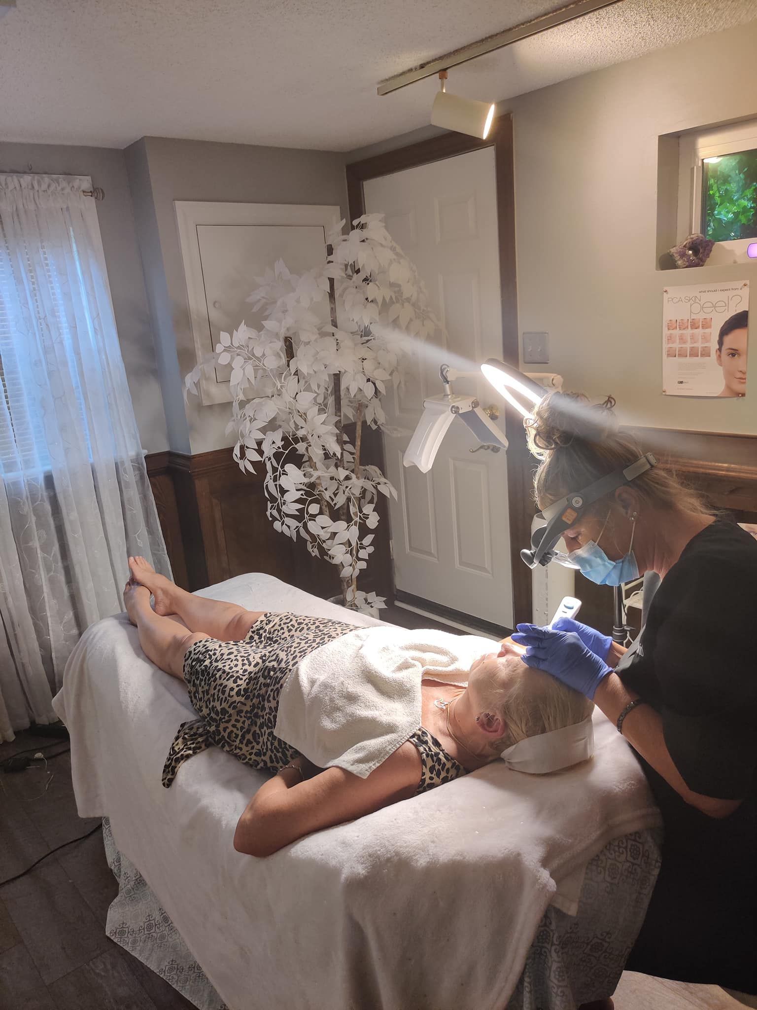 a woman is laying on a bed getting a facial treatment .
