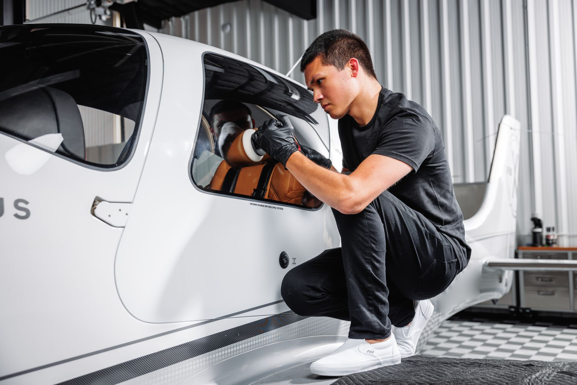 A man is working on a small airplane in a garage.