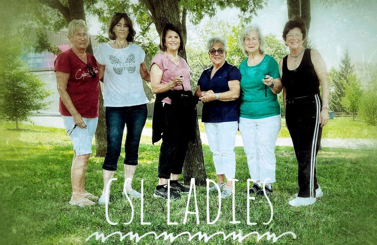 Women from photography class standing under a tree
