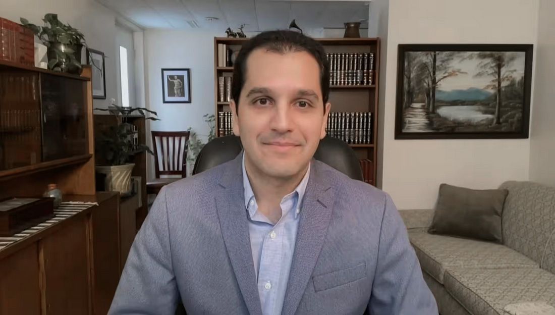 a man in a suit is sitting in a chair in a living room .