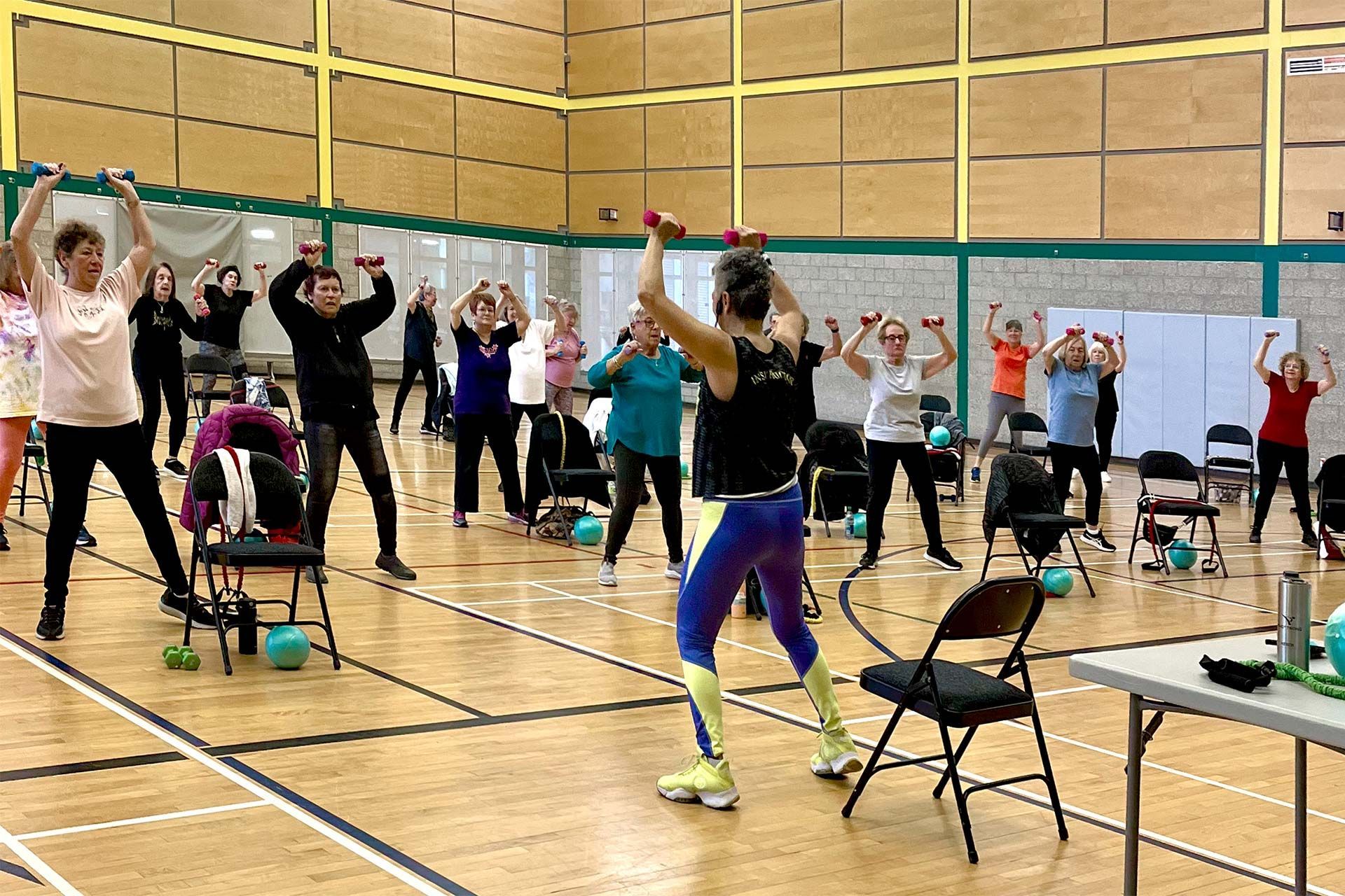 a group of people are exercising in a gym