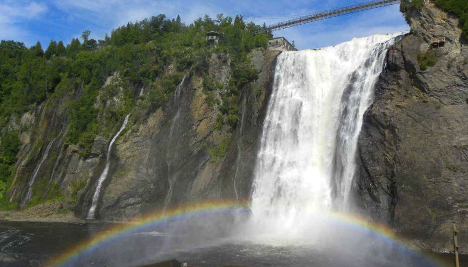 A waterfall with a rainbow in the middle of it
