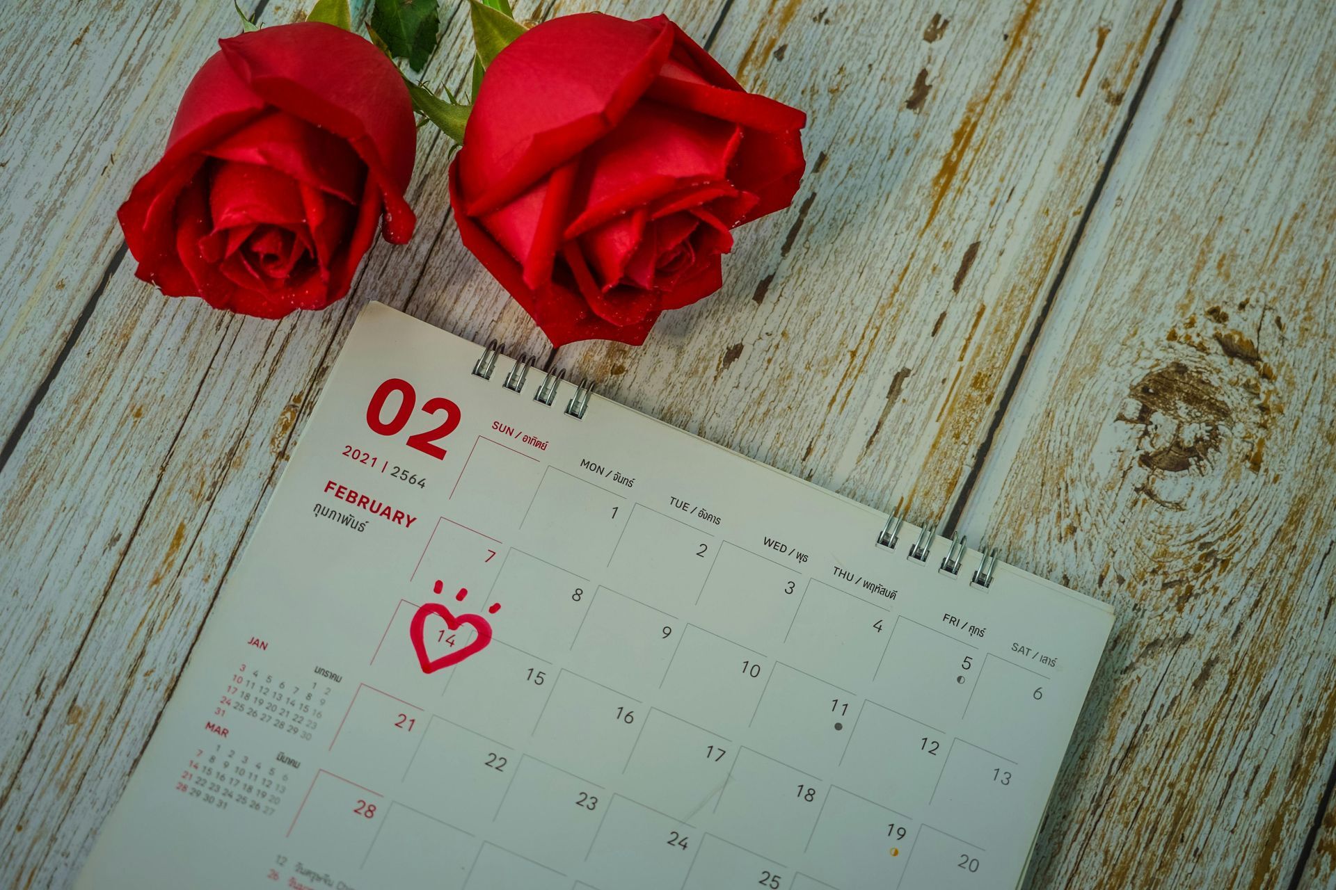 Red roses next to a calendar marking February 2nd with a heart.