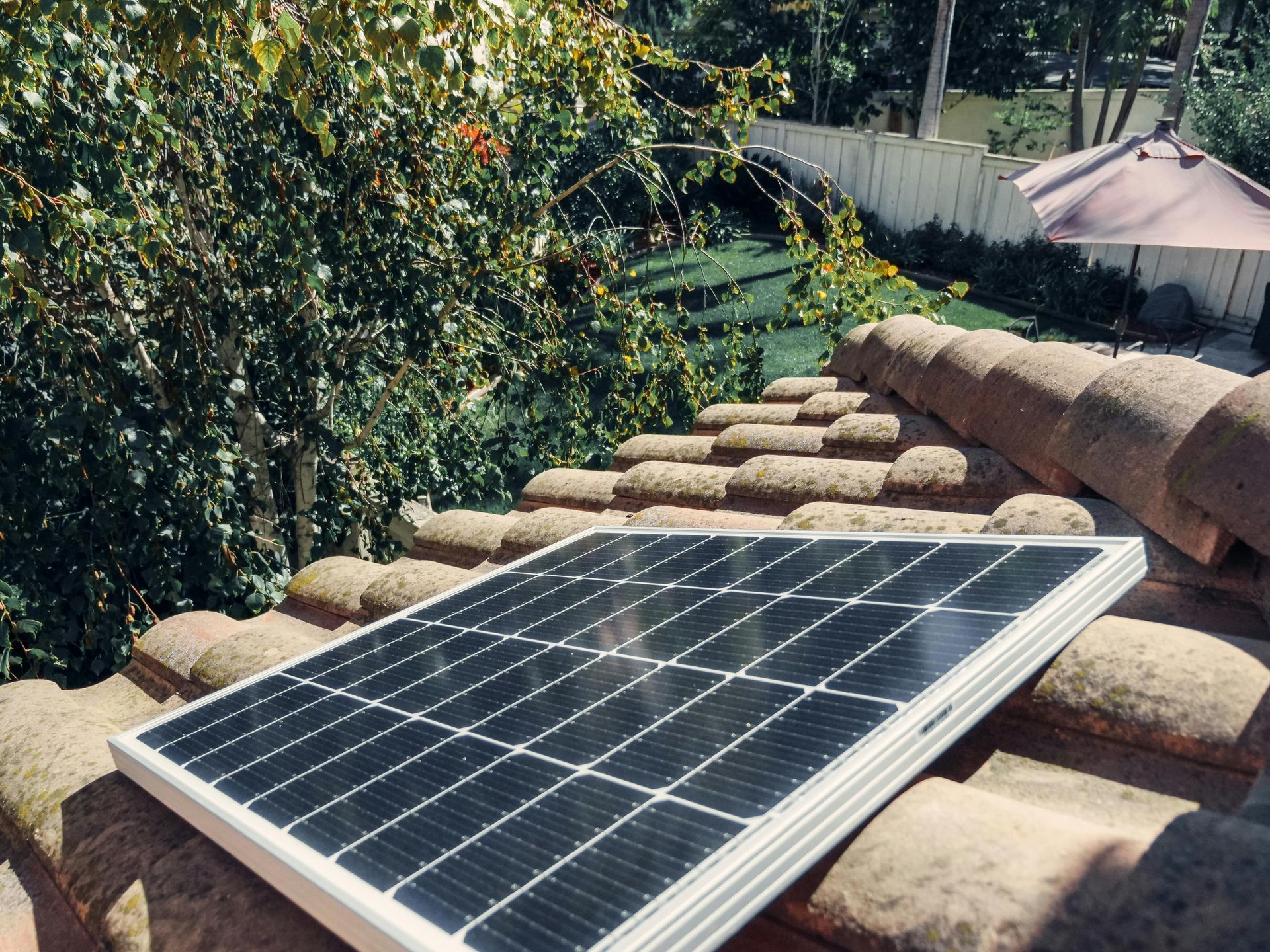 A solar panel is sitting on top of a tiled roof. A solar panel is sitting on top of a tiled roof.