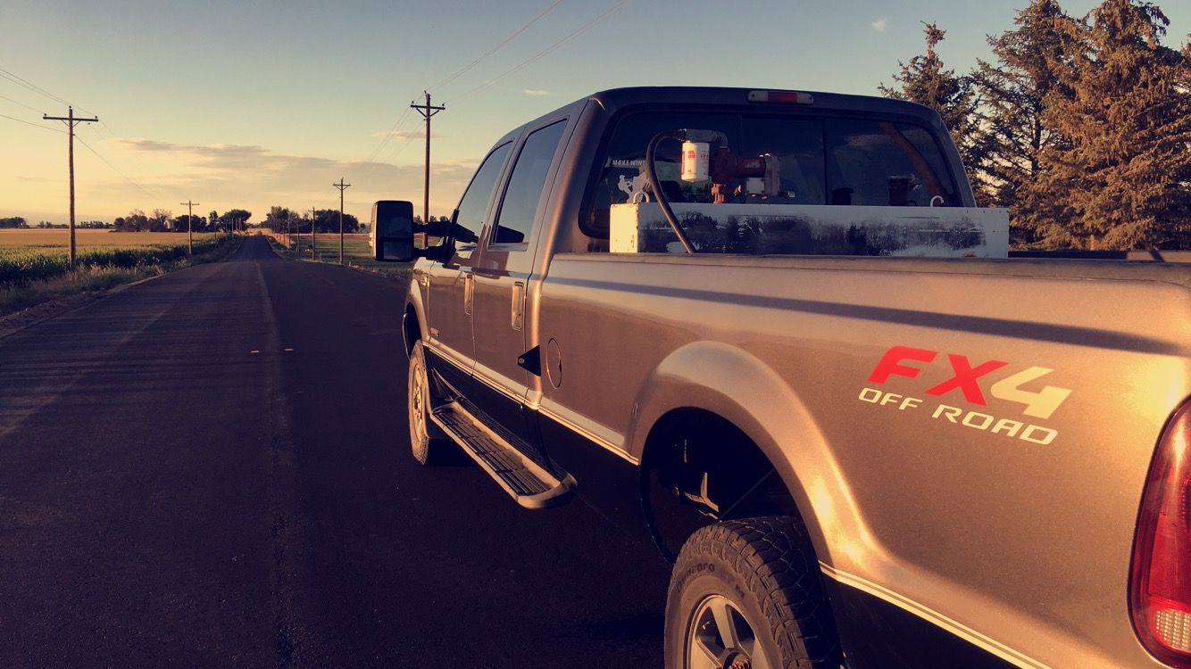 Pickup truck on a road at sunset, rear view with FX4 Off Road decal.