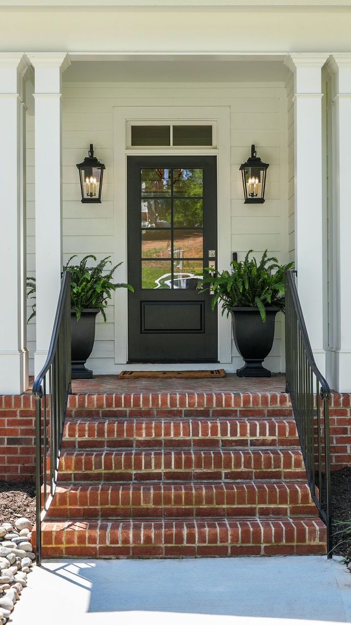 A house with a black door and brick steps