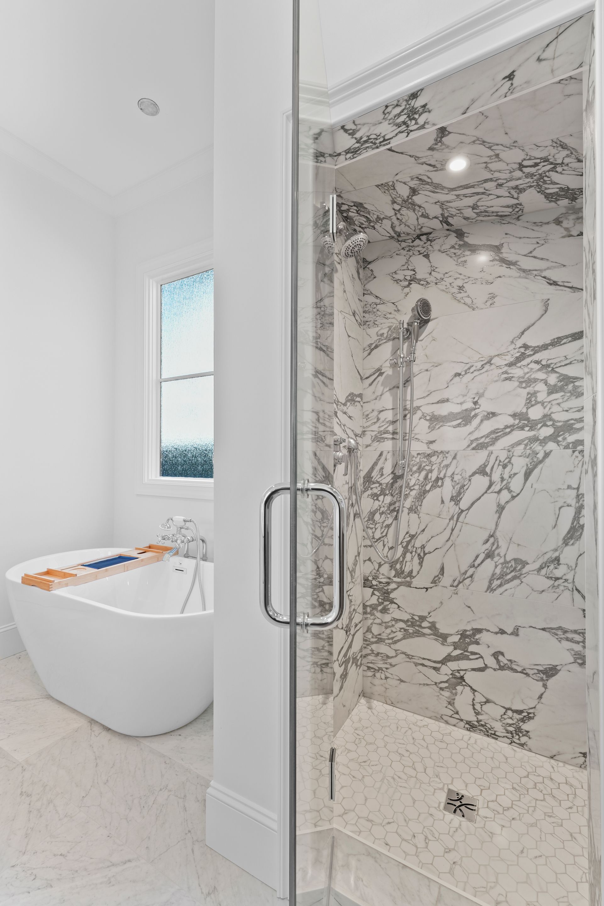 A bathroom with a bathtub and a shower with marble walls.