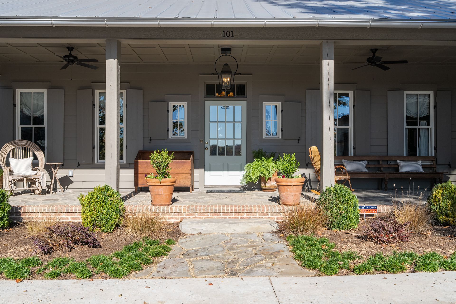 The front of a house with a porch and potted plants