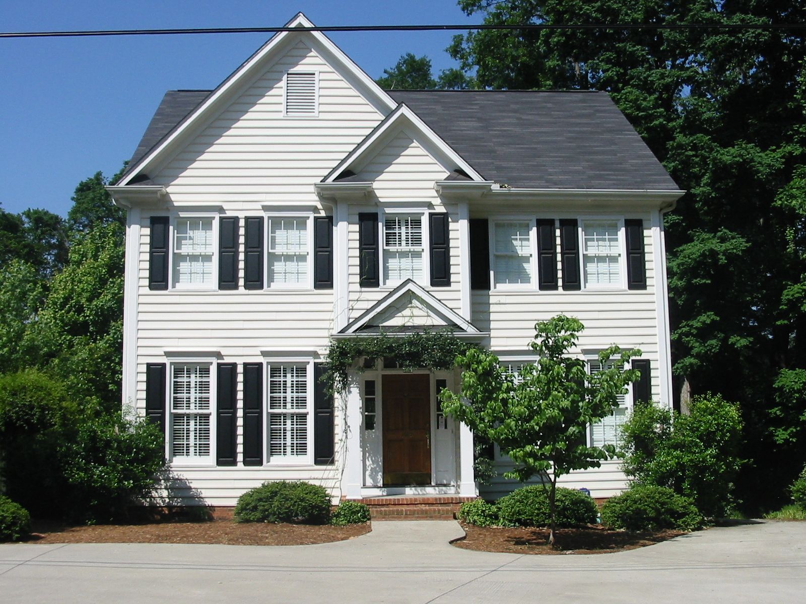 A large white house with black shutters on the windows