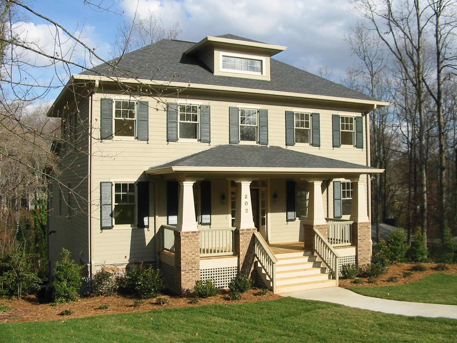 A large house with a gray roof and white shutters