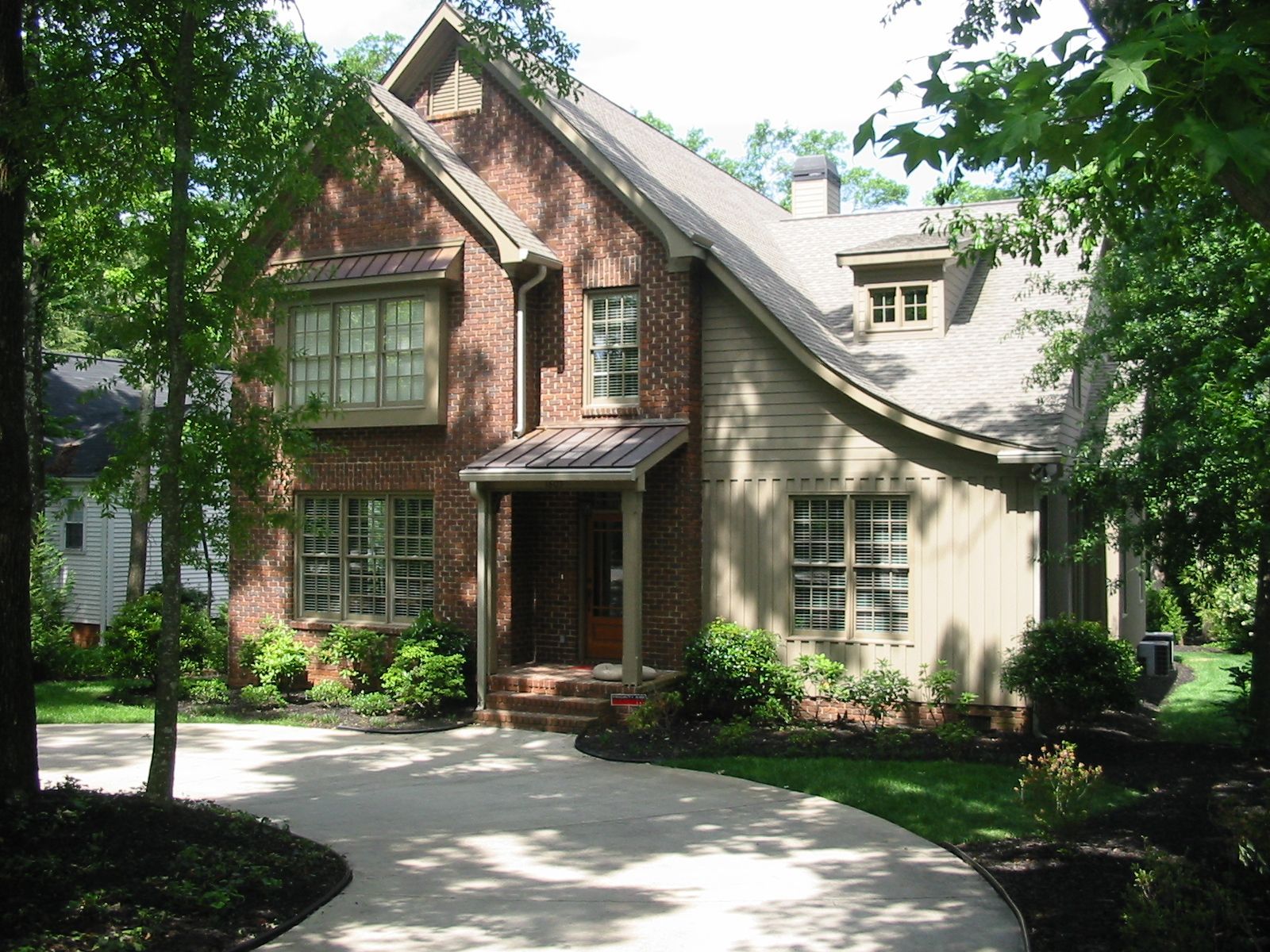A brick house with a driveway leading to it