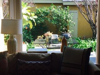 Living room view to garden with table, plants, and yellow wall.