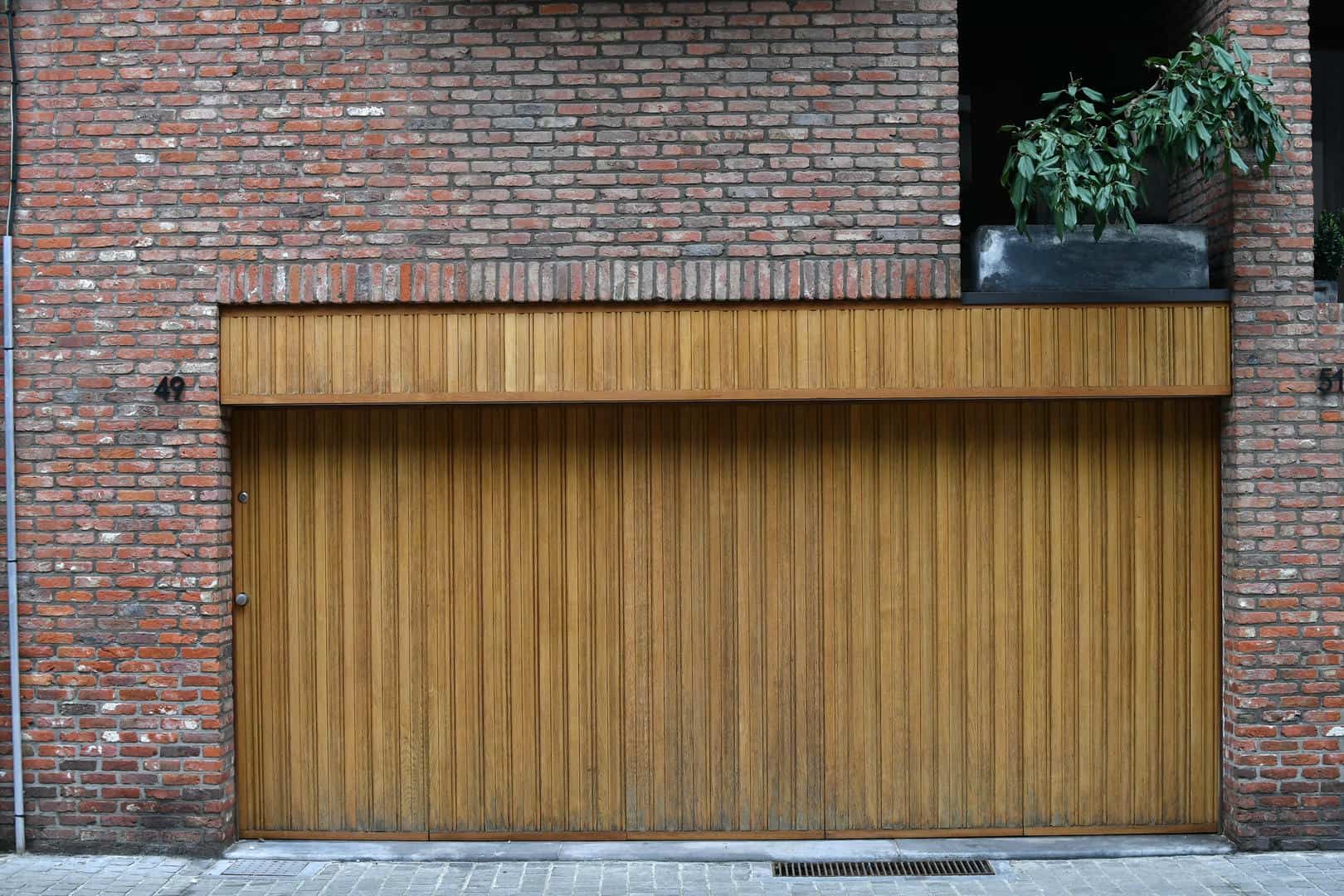 A brick building with a wooden garage door.