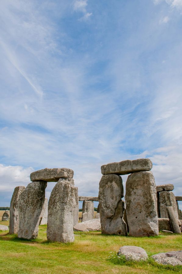 Stonehenge standing on green grass under a blue sky